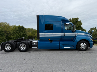 International LT625 truck side view showing blue sleeper cab and rear axle with fifth wheel.
