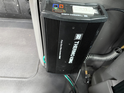 Thermoking auxiliary power unit/IDL inverter mounted in a truck cab showing label and connection ports.