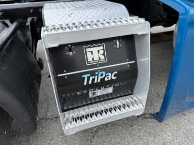 Semi truck side view showing TriPac Evolution auxiliary power unit with Diamond plate steps and Thermo King emblem.
