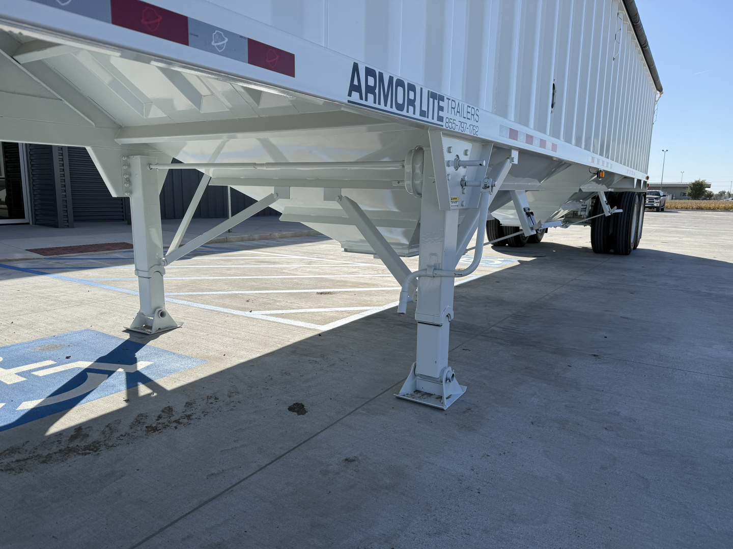 Armor Lite trailer legible text showing ARMOR LITE TRAILERS on the hopper side and structural support undercarriage.