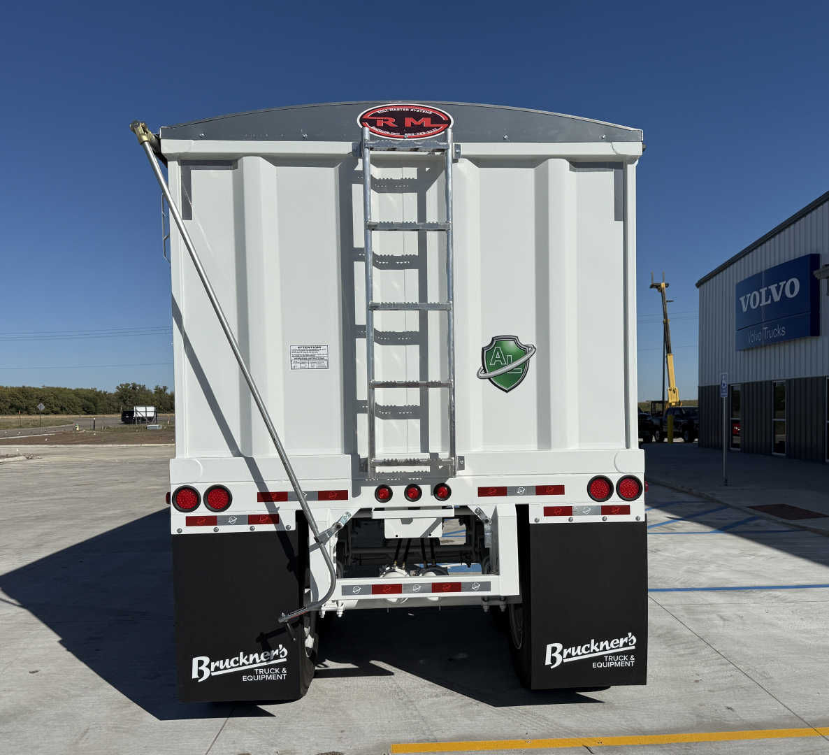 Rear view of 2027 Armor Lite 40' steel grain hopper trailer showing rear ladder, lights, mud flaps, and hydraulic hitch area.