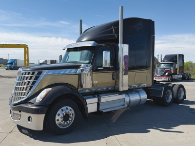 2022 International LoneStar conventional sleeper truck side view showing chrome front grille, dual exhaust stacks, and sleeper cab.