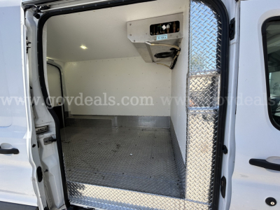 Ford Transit refrigerated van interior showing cargo area with diamond plate floor and overhead refrigeration unit.