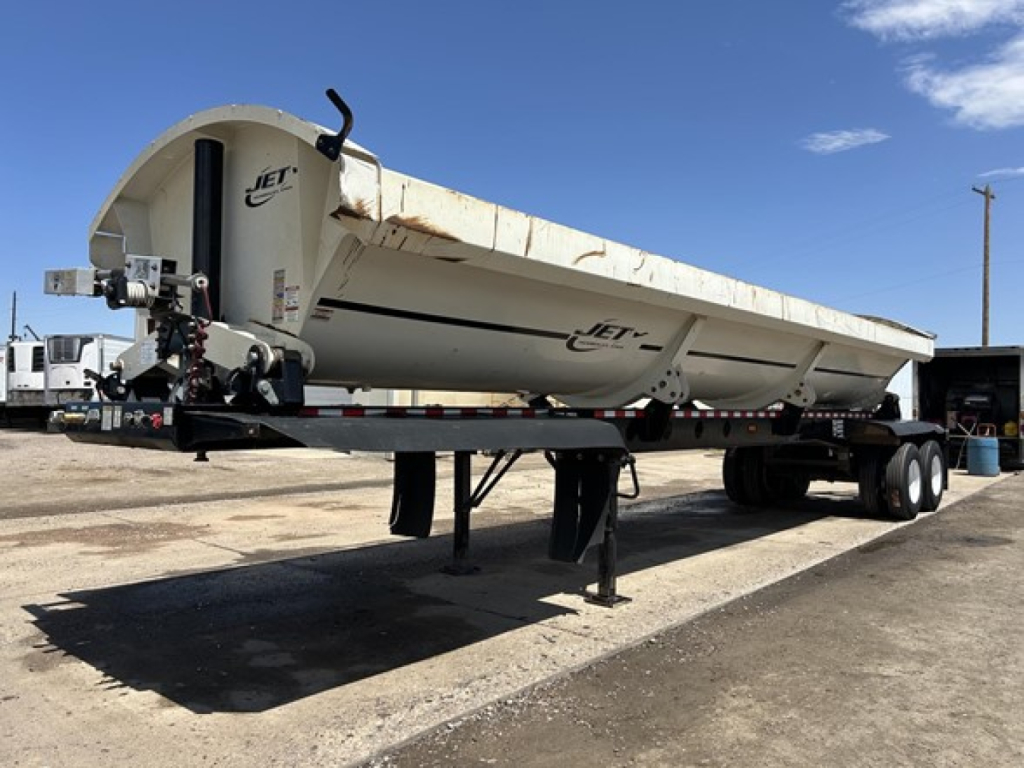 Jet Air Ride Side Dump trailer in a side profile view showing white body with Jet branding and support legs, parked on a lot.