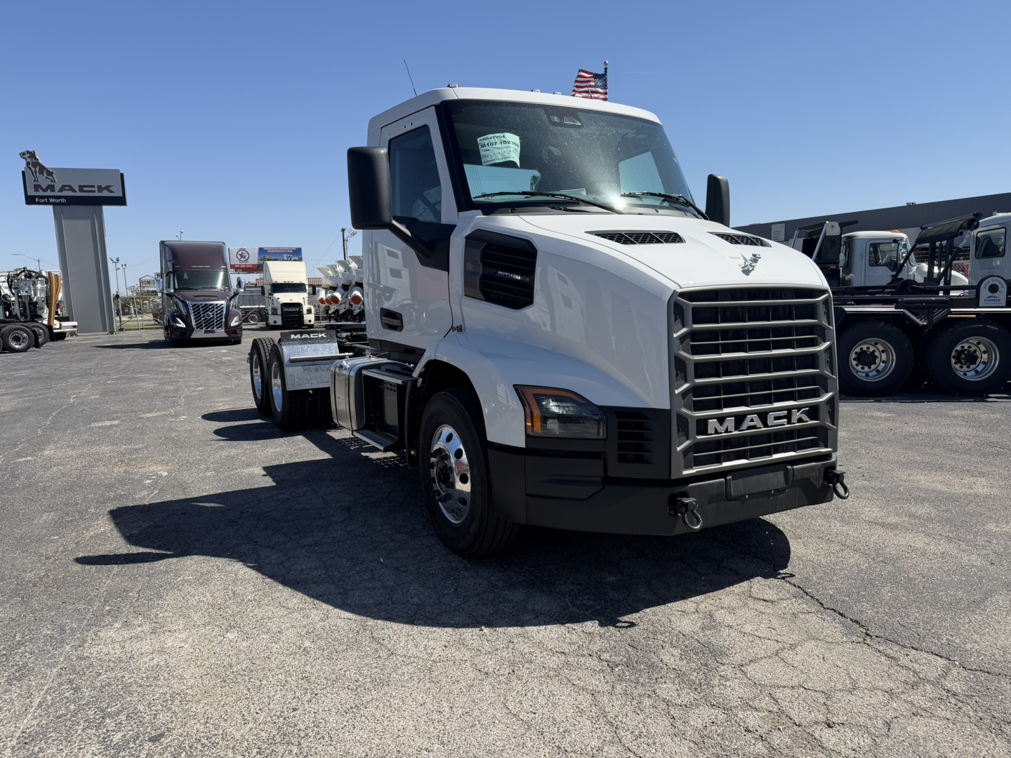 White 2027 Mack AN64T conventional daycab truck front-left view with grille and Mack emblem.