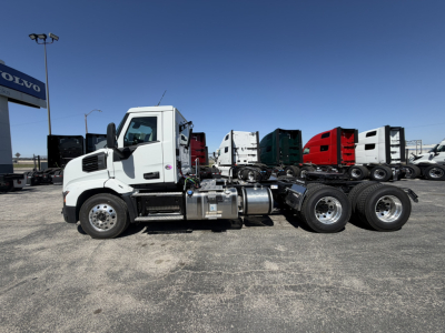 Truck side view showing 2027 Mack AN64T conventional daycab with dual rear axles and chrome fuel tanks.