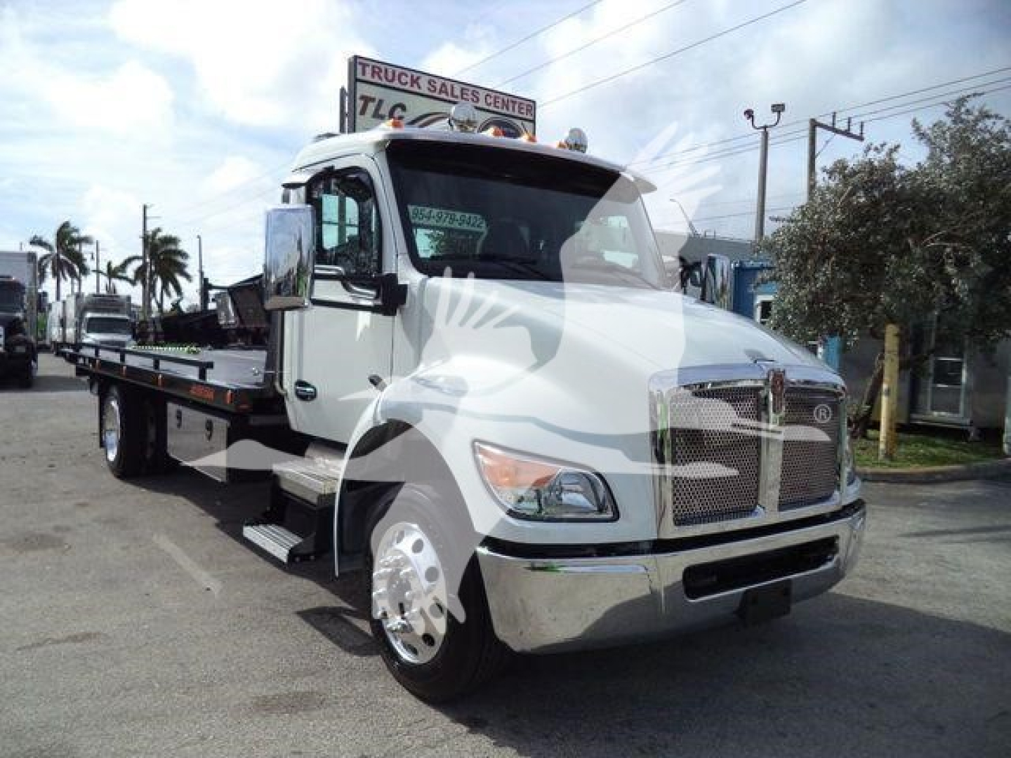 Kenworth T280 rollback tow truck front and side view showing cab and flatbed.