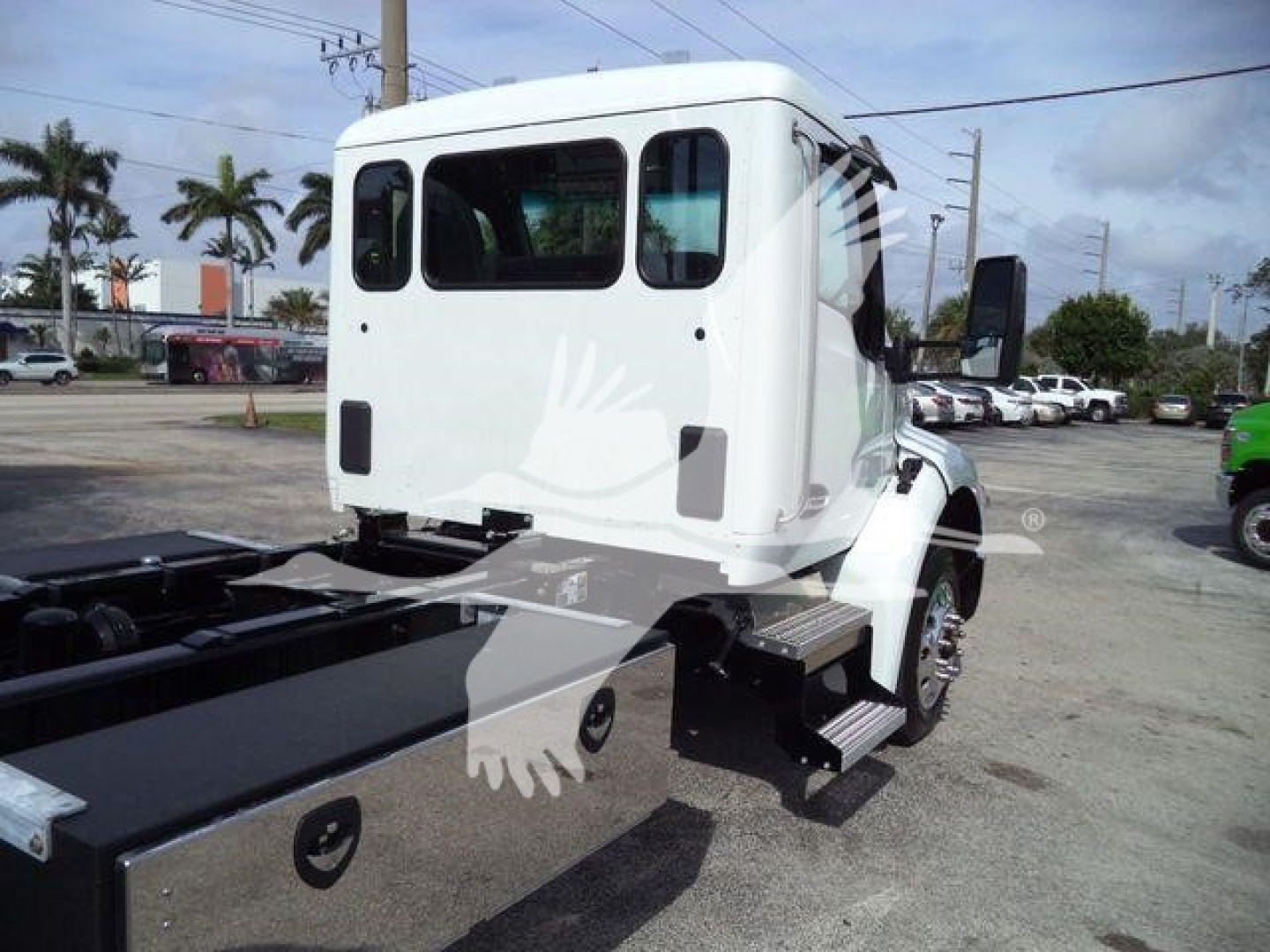 Truck cab rear view with white Kenworth T280, rollback chassis visible, side steps, windows, and rear door area.