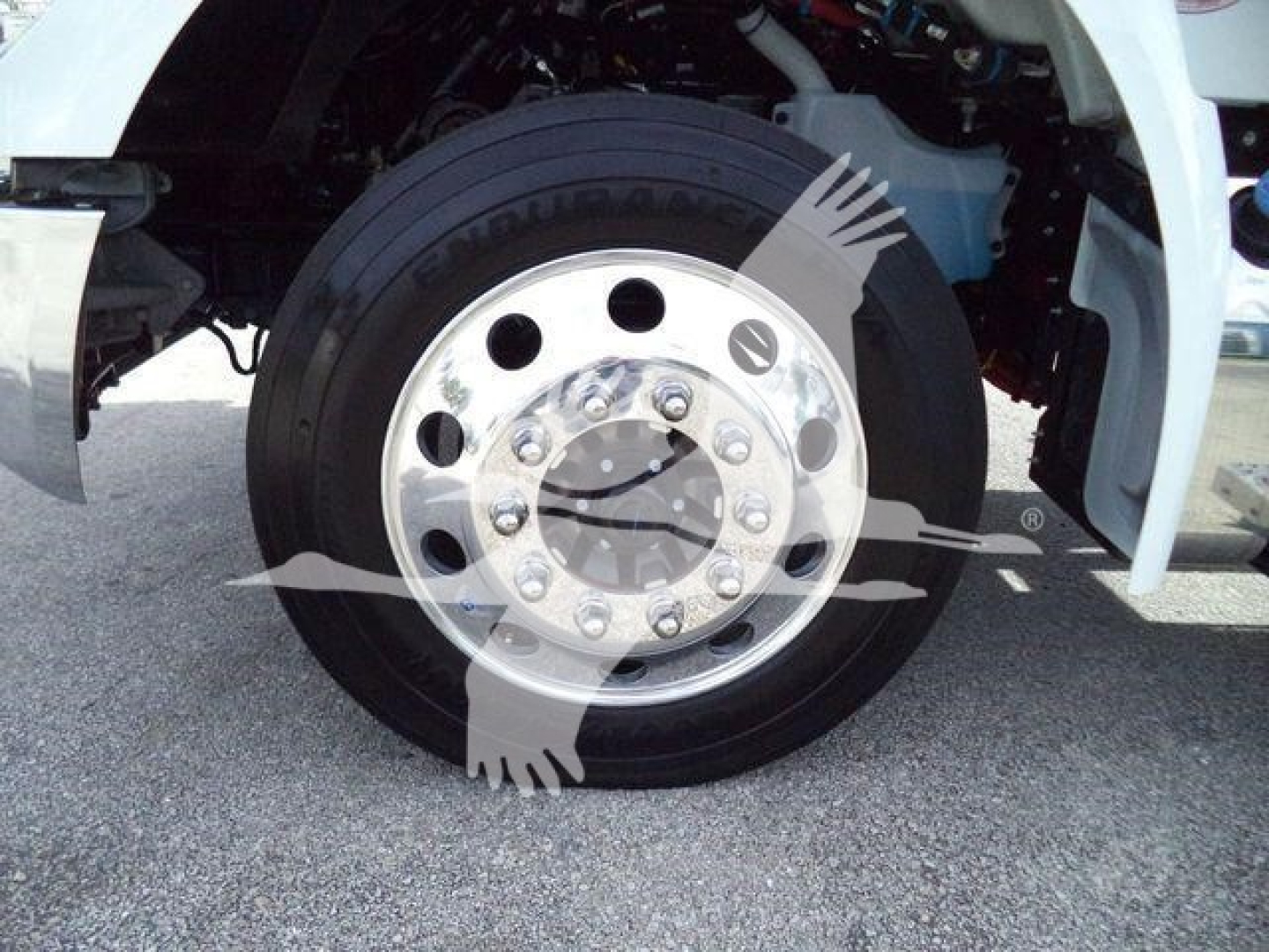 Truck front wheel and fender showing steel wheel with lug nuts and tire, part of a Kenworth T280 semi-truck cab in a rollback configuration.