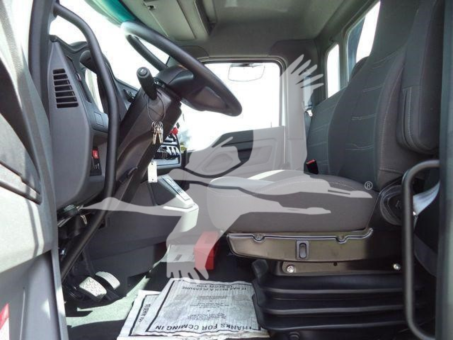 Kenworth T280 truck cab interior showing driver seat and steering wheel with controls and dashboard from side view.