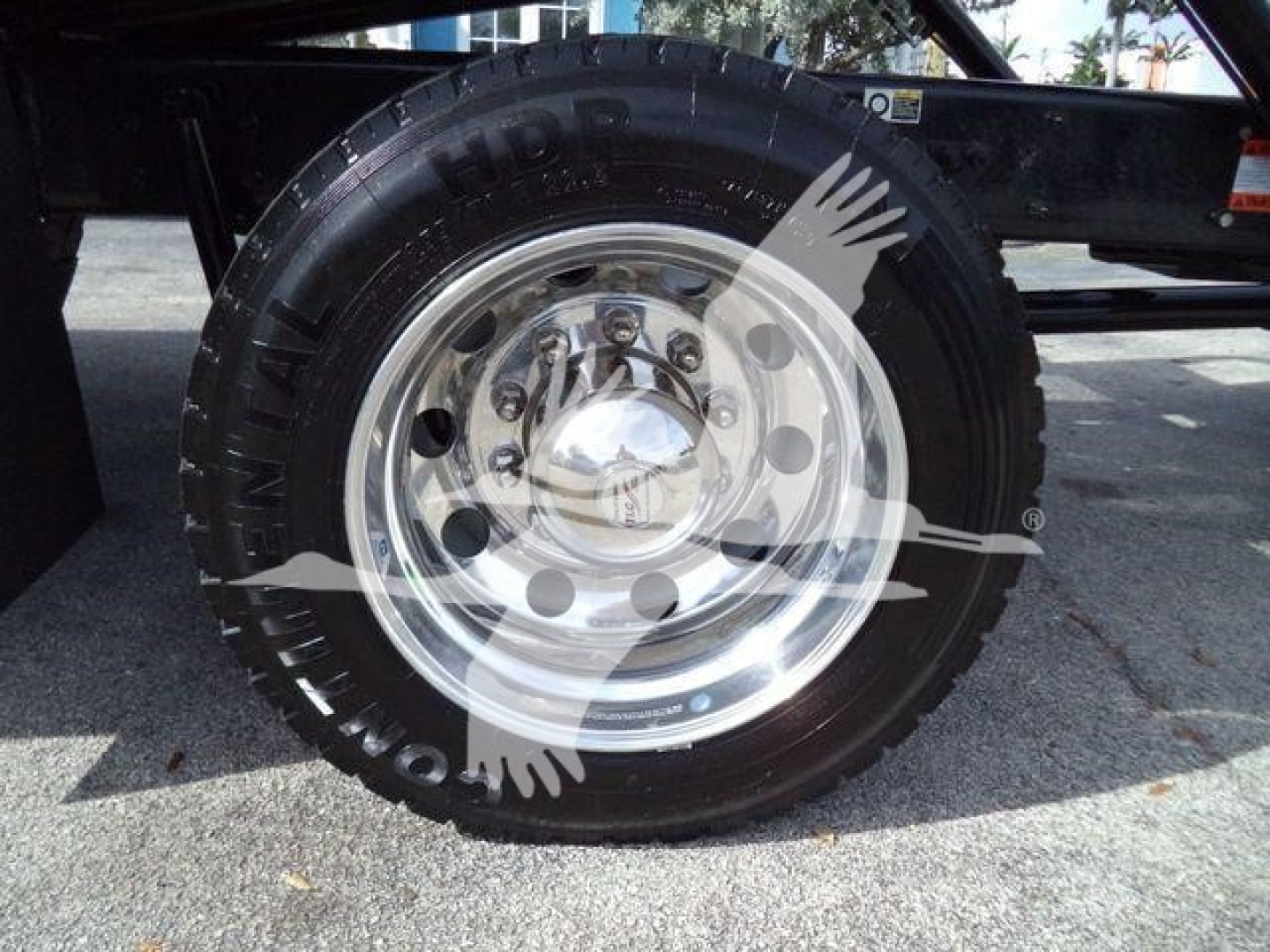 Wheel and tire of a 2025 Kenworth T280 truck showing polished steel hub and tire sidewall text.