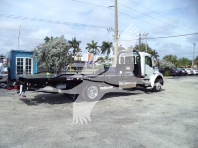 Kenworth T280 rollback tow truck side view showing long flatbed and wheel-lift equipment with cab and chassis