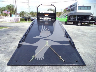 Kenworth tow truck rollback bed showing flatbed with hooks and chains in front, rear headboard visible