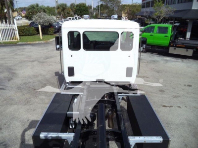 Truck cab of a Kenworth T280 with rollback chassis showing rear view and hydraulic components.