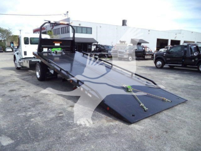 Kenworth T280 rollback tow truck with a lowered flatbed platform and wheel ramps visible in foreground.
