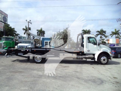 Kenworth T280 rollback tow truck side view showing flatbed and white cab with black chassis undercarriage.