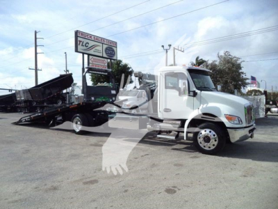 2025 Kenworth T280 rollback truck in light blue with loading bed extended showing wheel and cab view.