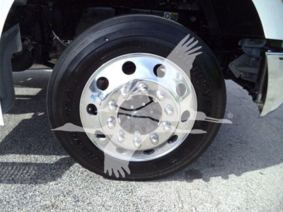 Wheel of a Kenworth truck showing polished steel rim with multiple lug nuts and black tire; faint watermark image overlay across center.