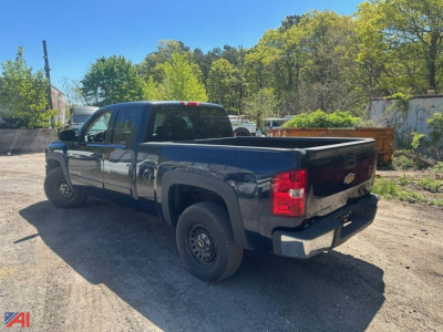 Chevrolet Silverado 1500 extended cab pickup truck in a dark color, 4x4, rear three-quarter view, bed exposed.