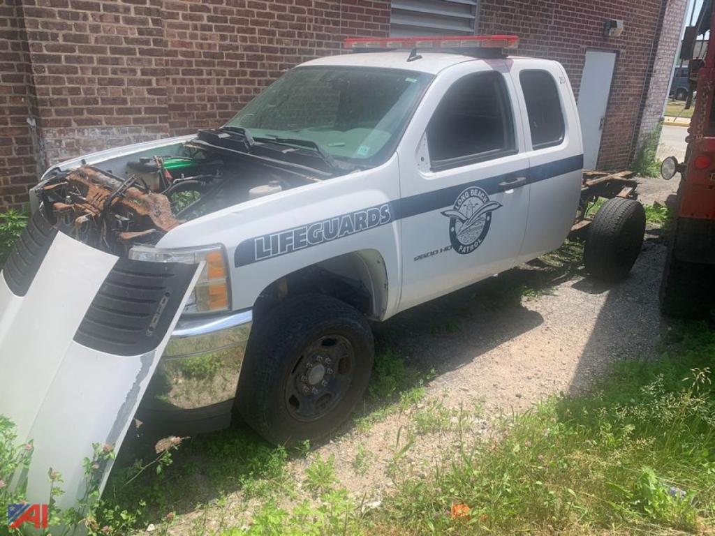 Chevrolet Silverado 2500HD 4x4 utility pickup in service with lifeguards decal, front hood open showing engine area and removed front bumper panels.