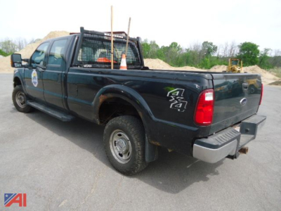 Ford F-350 Super Duty pickup truck 2015 crew cab with utility racks and rear tailgate, 4x4 badge, dark green paint.