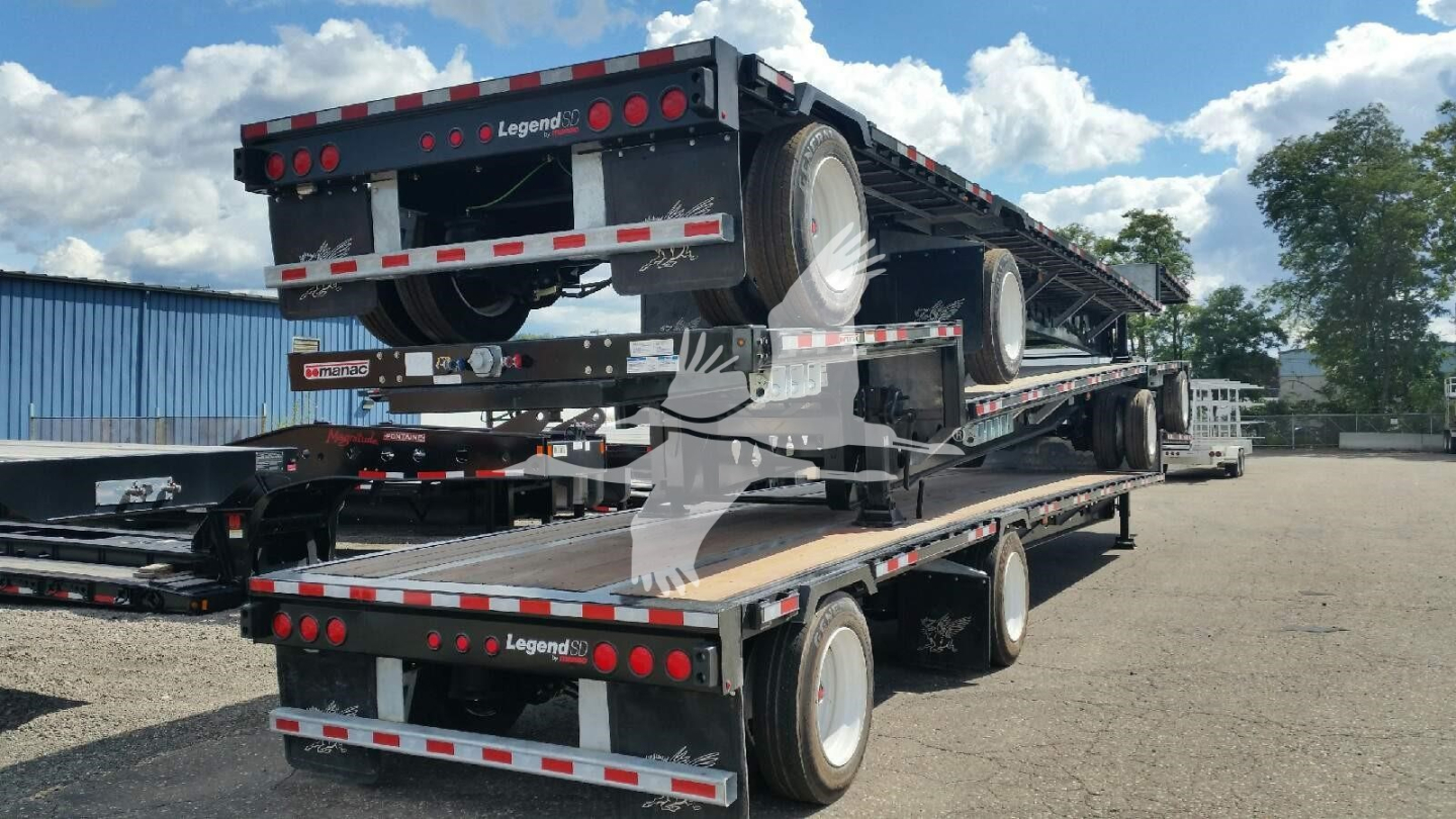 Trailer deck with stacked flatbed trailers, brand markings Legend trailer, rear and side lights, black frame, spare tires mounted on upper deck.
