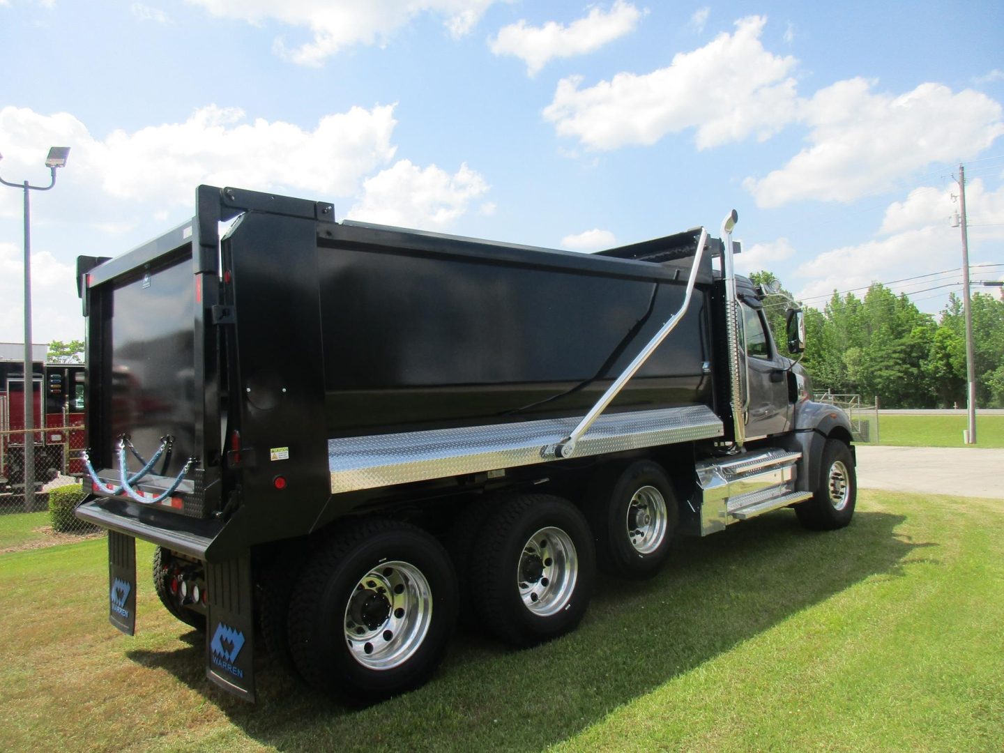 Western Star 49X dump truck side view showing heavy-duty dump body and three rear axles.