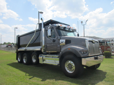 Dump truck in yard showing Western Star 49X cab and dump bed, chrome front bumper, dual rear axles, and side steps.