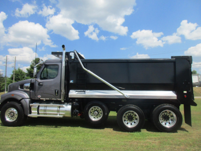 Western Star 49X dump truck side view showing large black dump bed and chrome steps.