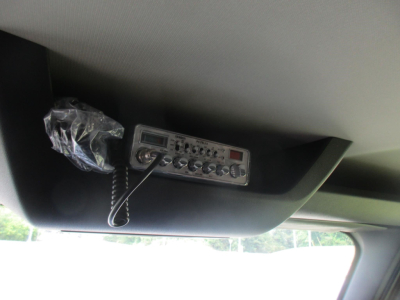 Cab interior overhead console with radio microphone and CB-like control panel mounted in storage area of Western Star 49X truck cab