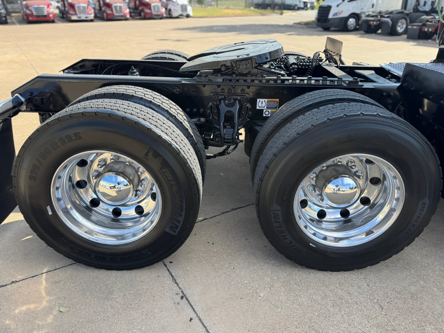 Kenworth T680 chassis with dual rear wheels and chrome hubcaps showing undercarriage and fuel rails.