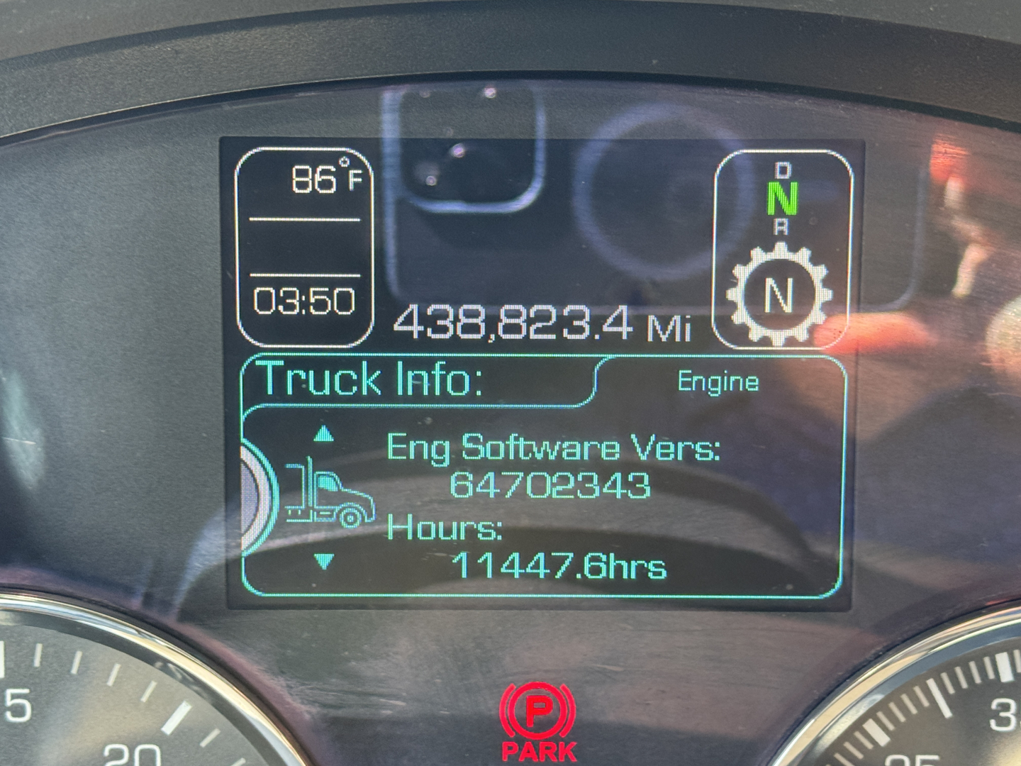 In-cab display of 2021 Kenworth T680 showing engine software version, hours, and mileage. Dash reads 438,823.4 miles; time 03:50; outside temperature 86°F. Gear indicator shows D N R with N engaged. Truck Info panel lists Eng Software Vers