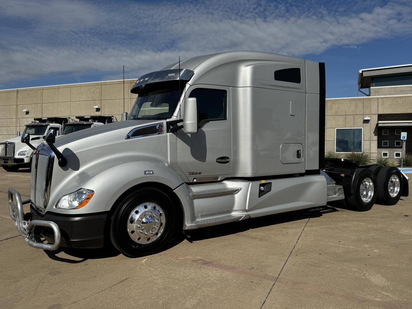 Kenworth T680 tractor showing grille, hood, and silver exterior; no visible text legible other than general truck features.
