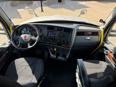 Kenworth T680 cockpit view showing steering wheel, dashboard, and center console with controls.