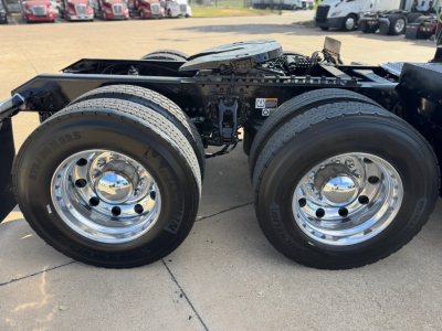 Kenworth T680 chassis with dual rear wheels and chrome hubcaps showing undercarriage and fuel rails.
