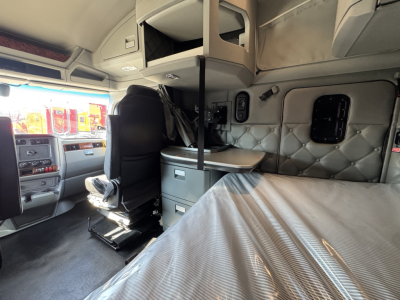 Kenworth truck sleeper cab interior showing bunk bed and storage cabinets.