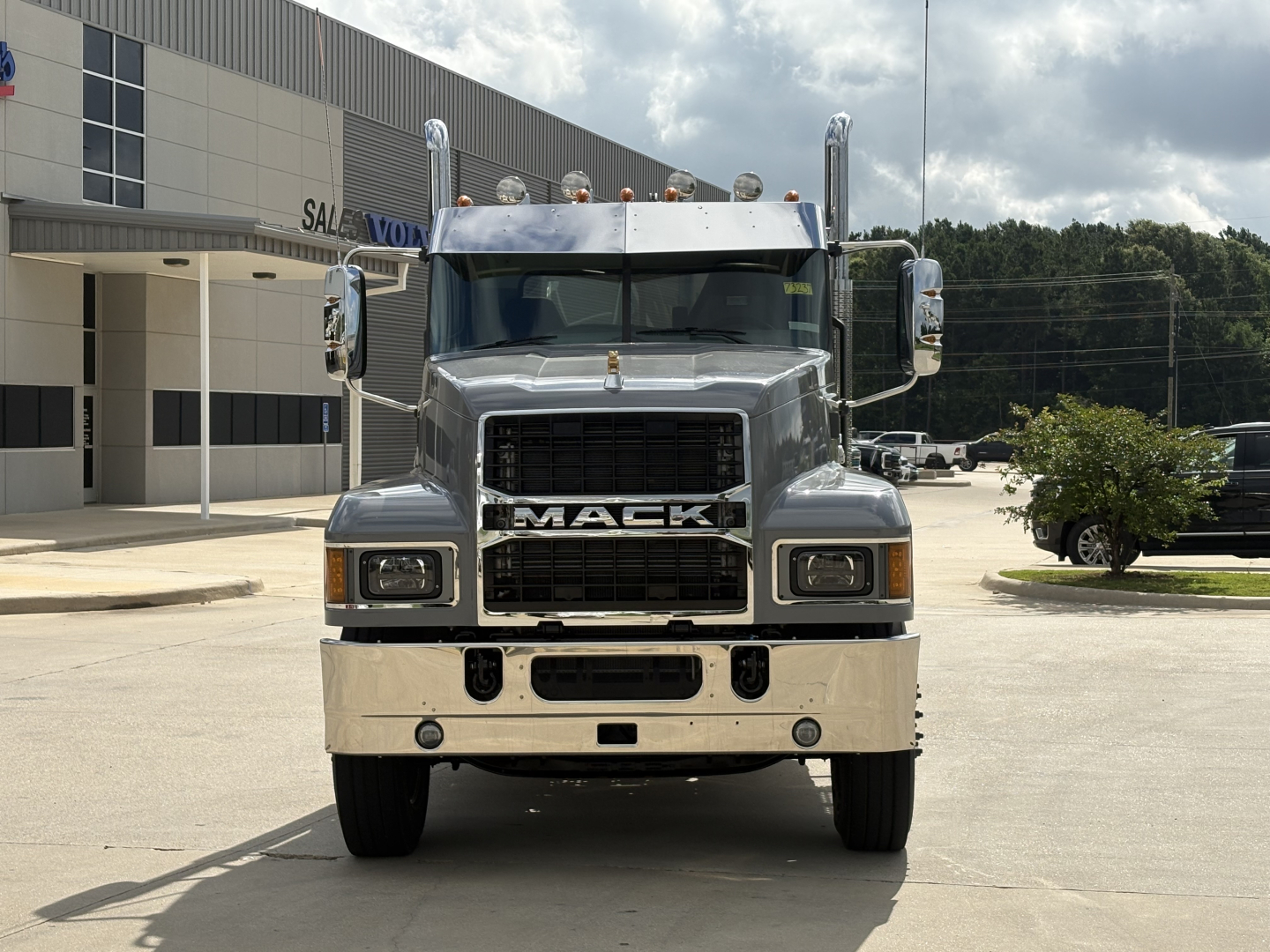 Front view of a brand-new 2027 Mack PI64T conventional daycab truck with chrome grille, large bumper, and dual stacked headlights.