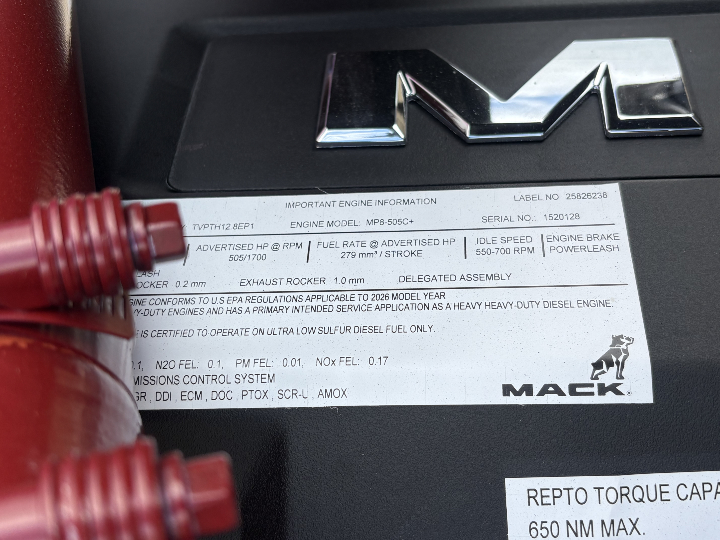 Engine information label inside Mack PI64T truck showing engine model, serial numbers, and other specifications.