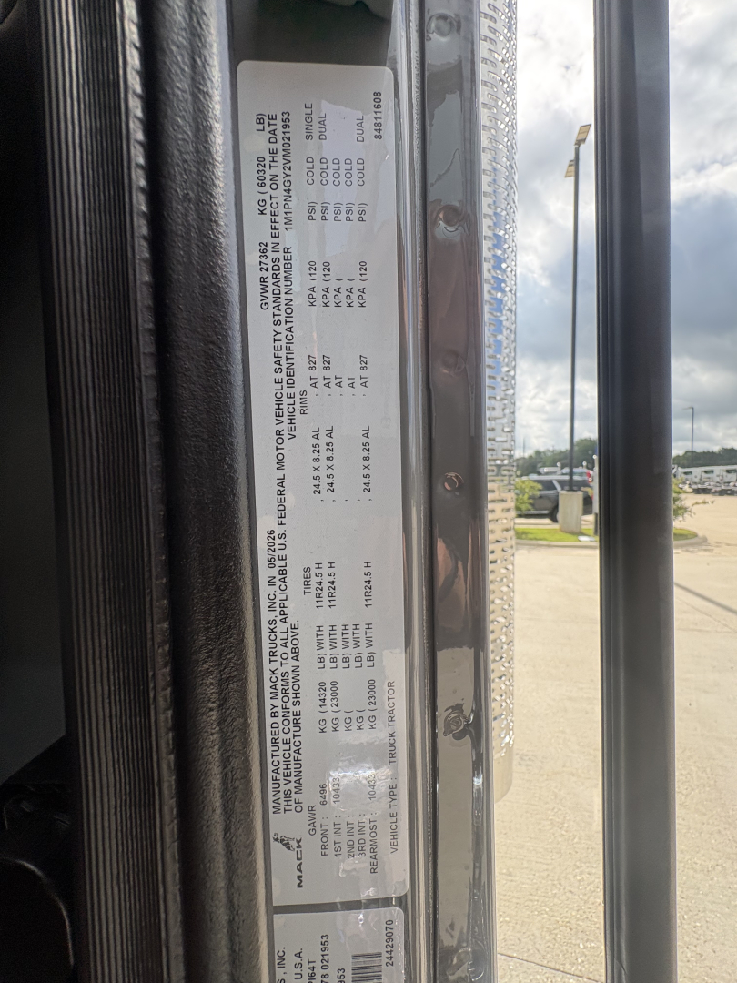 Label plate on Mack PI64T showing vehicle specifications and tire/wheel data with VIN1M1PN4GY2VM021953 and stock info.