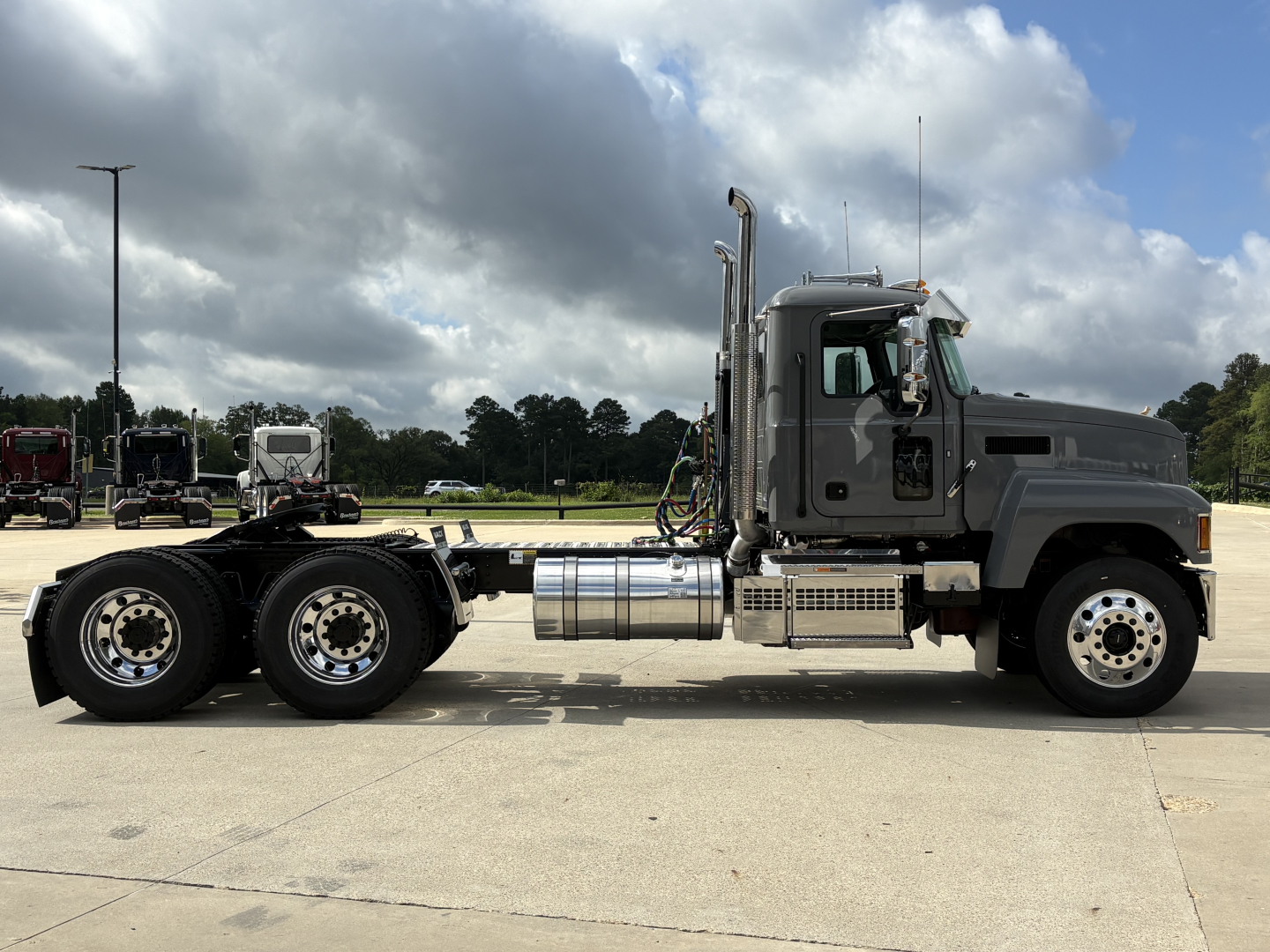 Mack PI64T conventional daycab truck side view showing chassis, cab, fuel tanks, exhaust stacks, and large dual rear axles.