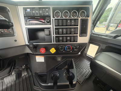 Dashboard of a new 2027 Mack PI64T truck showing gauge cluster, control switches, and gear selector with multiple push buttons and climate controls.
