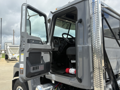 Truck cab interior and door open showing steering wheel and dashboard with open door and steps.