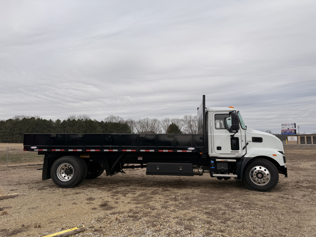 2025 Mack MD7 flatbed truck side view showing dump-style bed with black rails and white cab.