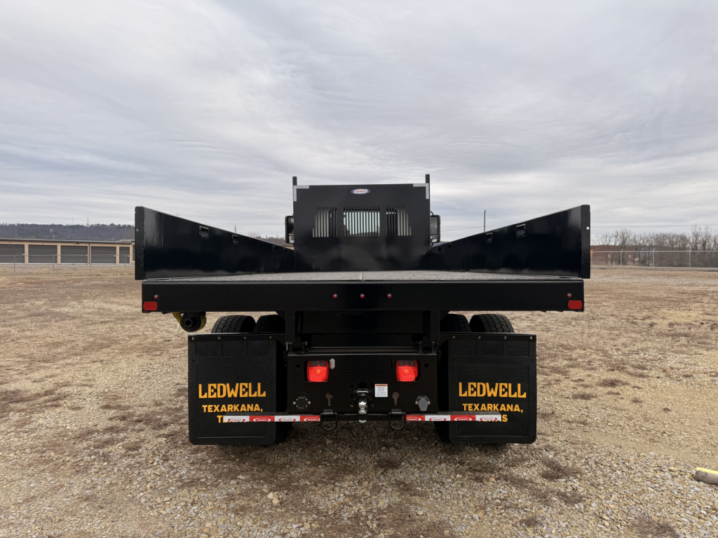 Flatbed truck chassis rear view showing LEDWELL mud flaps Texarkana branding and towing components