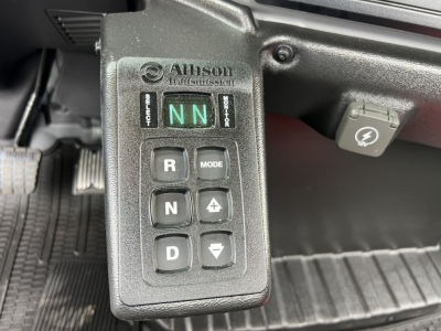 Alison Technologies electronic gear selector panel showing NN in indicator, R, N, D mode buttons, and charging port nearby inside Mack MD7 cab.