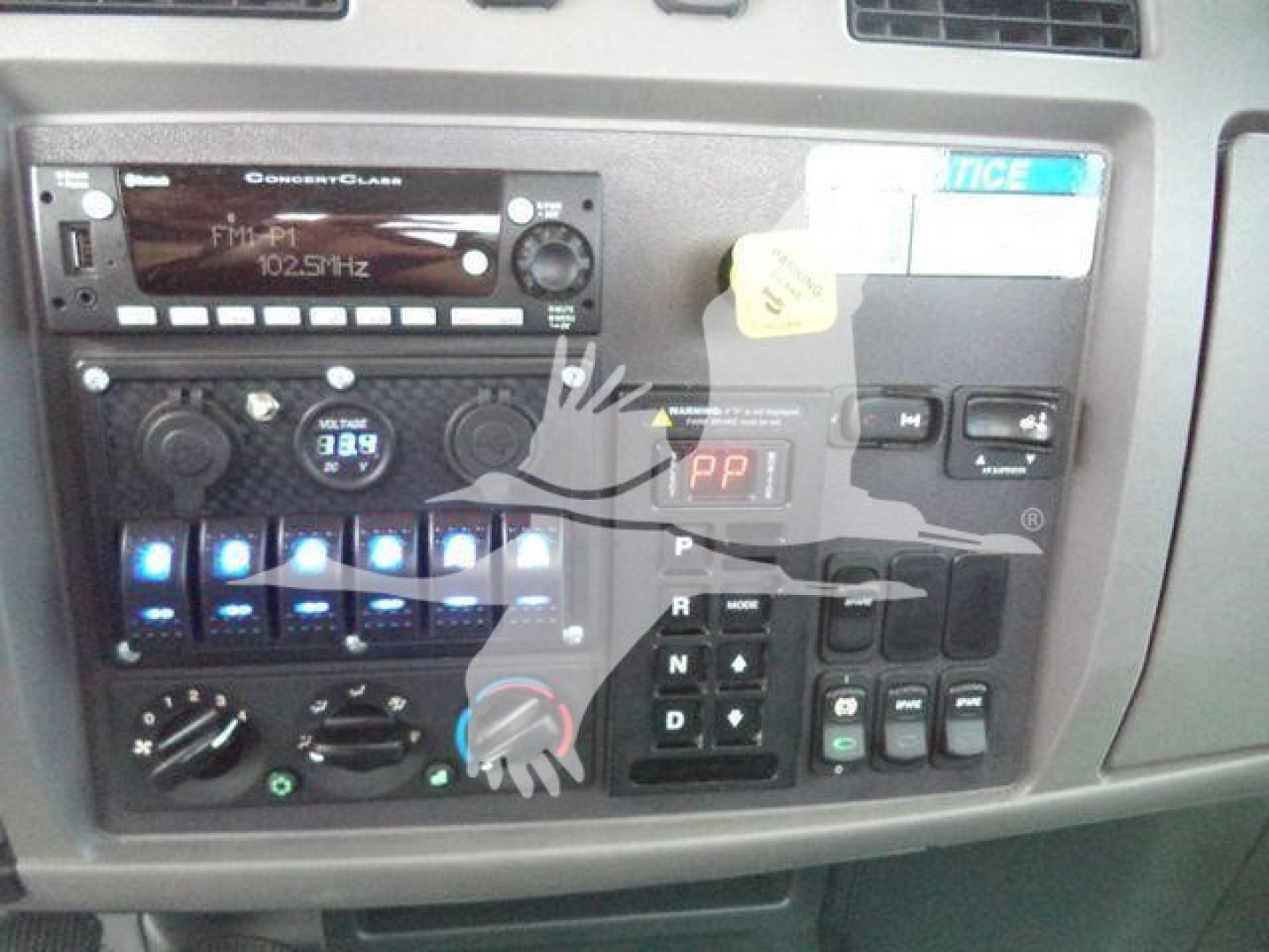 Peterbilt 337 instrument cluster and center console showing radio, climate controls, and gear selector with labeled buttons.