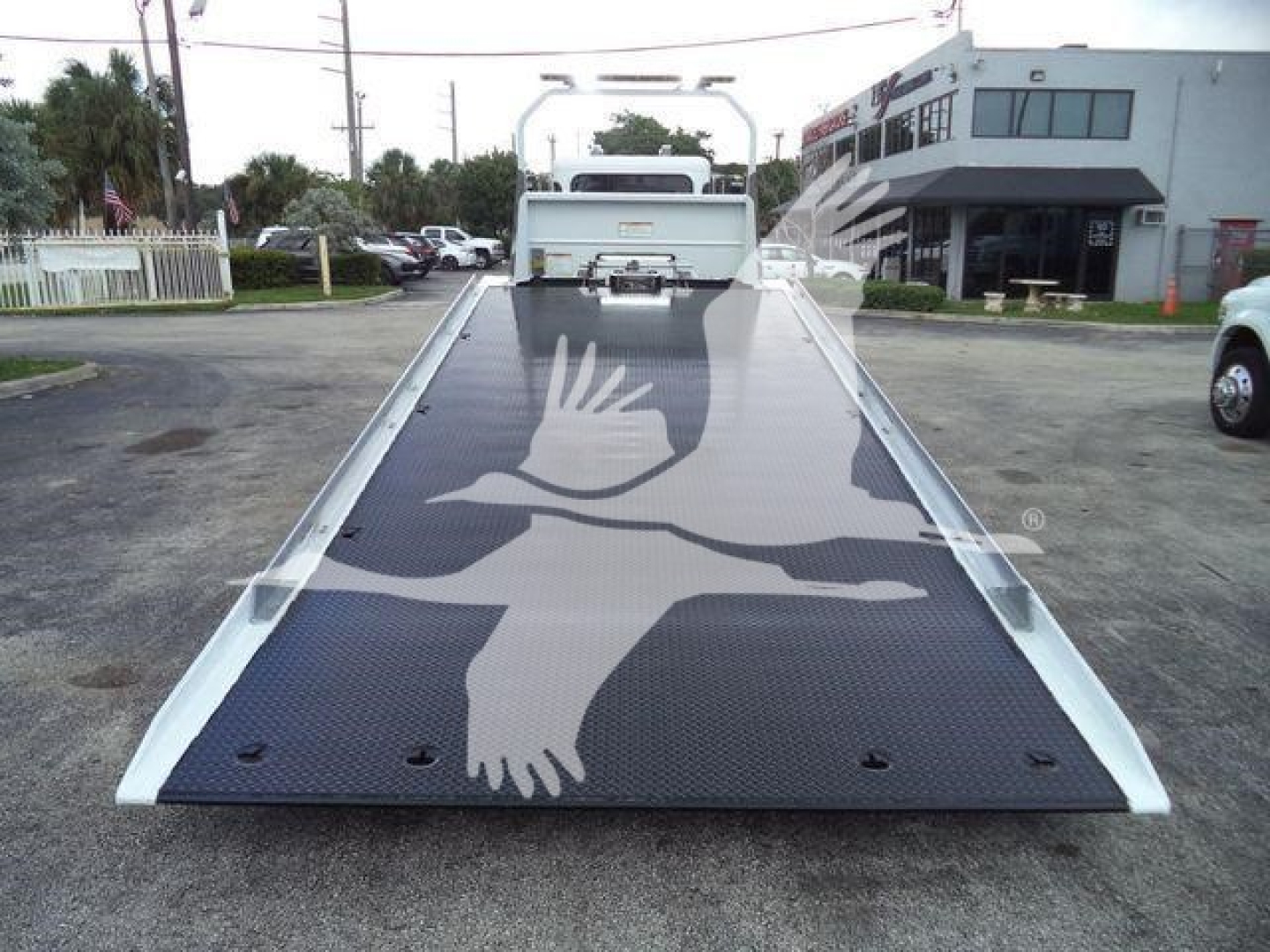 Peterbilt 337 rollback tow truck flatbed with graphic dove design viewed from rear deck.