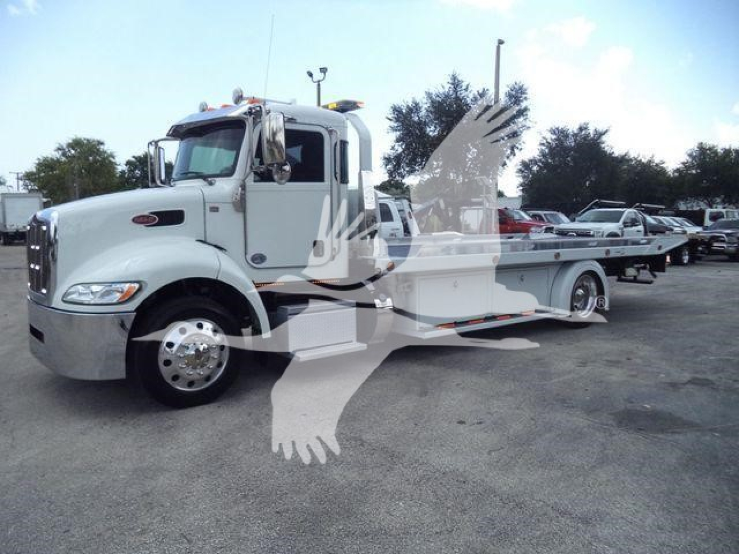 Peterbilt 337 rollback tow truck side view showing cab and flatbed with chrome wheels and light mounting.