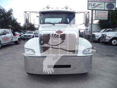 Peterbilt 337 front view in a truck lot with chrome grille and bumper, white cab, stock number J61994FM in background.