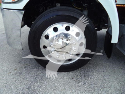 Front wheel and chrome hubcap of a Peterbilt 337 truck showing polished steel rim and tire sidewall.